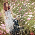 Femme asiatique - dans un champ de fleur - mobylette
