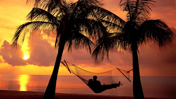 Couple hamac - plage coucher de soleil